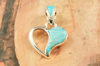 Genuine Sleeping Beauty Turquoise inlaid between ribbons of Sterling Silver. Free 18" Sterling Silver Chain with Purchase of Pendant. Beautiful Heart Pendant Designed by Navajo Artist Calvin Begay. Signed